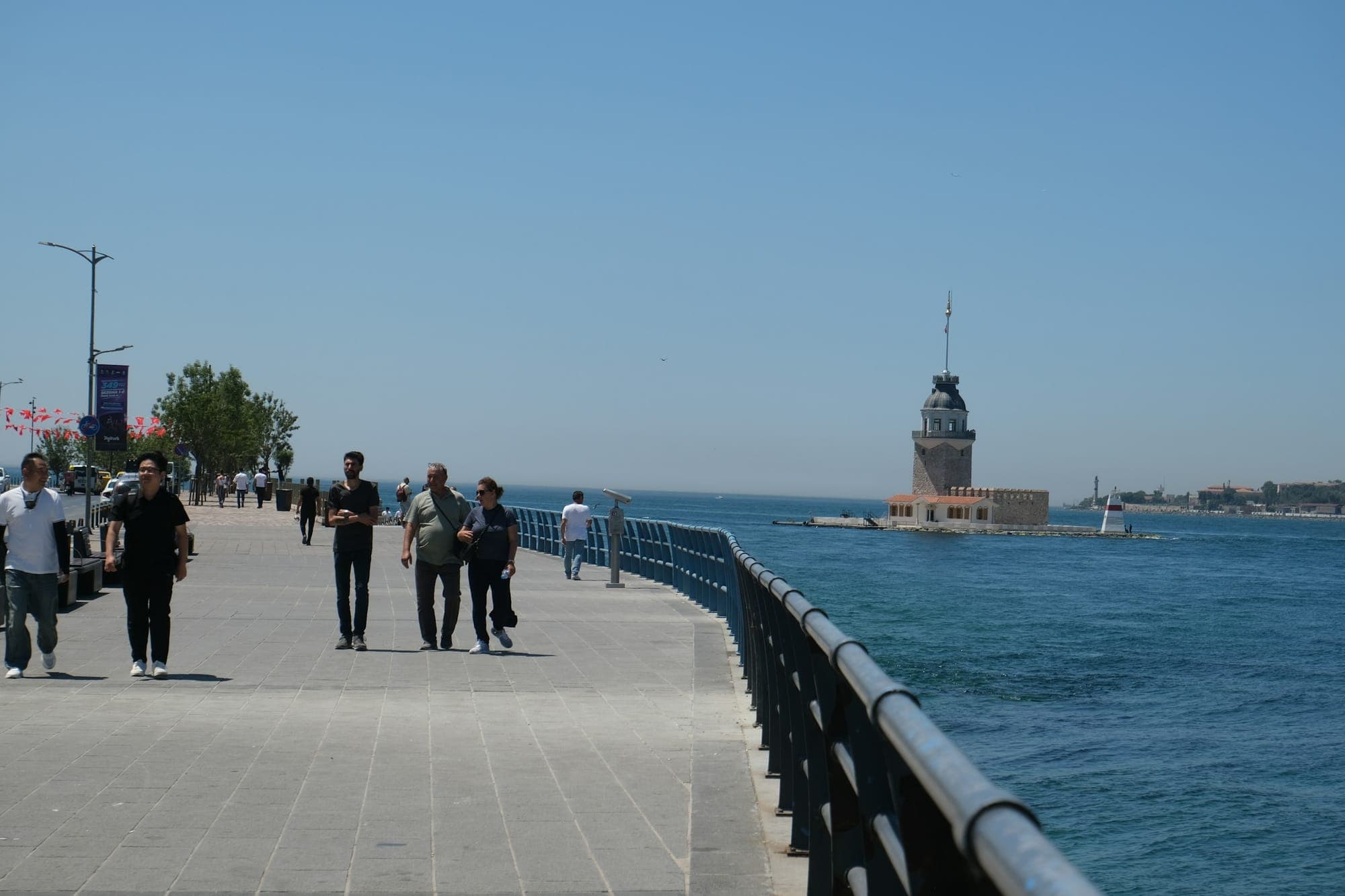Üsküdar sahilinde yürüyen insanlar, karşıda Kız Kulesi